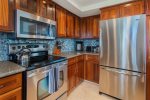 The kitchen is complete with custom, hardwood cabinets and all stainless-steel appliances, including a full-size freezer/fridge, dishwasher, stove, oven and microwave